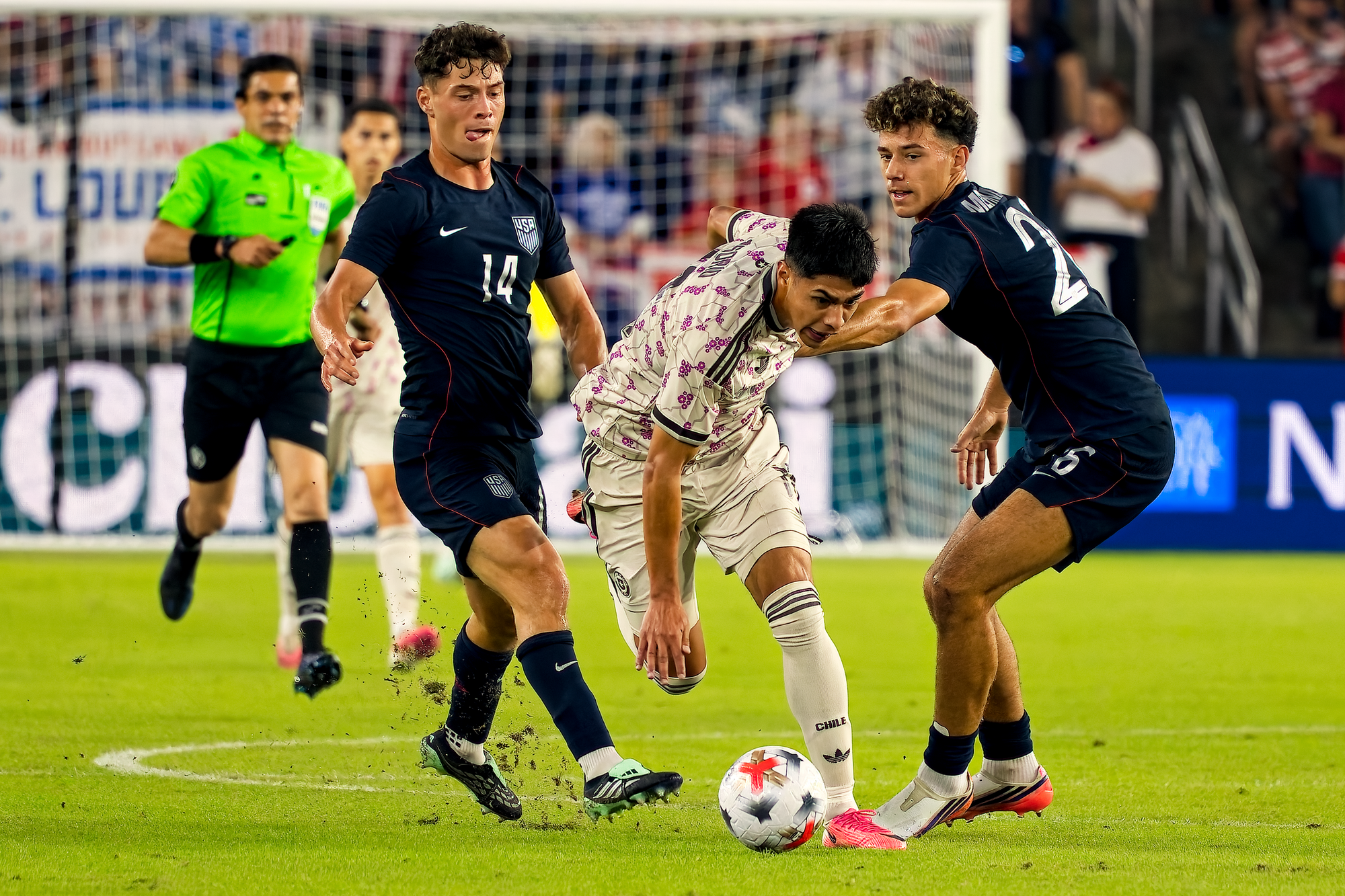 United States midfielder Adri Mehmeti tackles Chile winger Darío Osorio as teammate Sebastian Berhalter closes in, with the referee and the goal behind them.